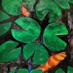 Koi
Zwei Fische, schräg und voller List,
im runden Glas, wo Stille ist.
Da treiben, leicht und fast versteckt,
Seerosenblätter, sanft bedeckt.
Der eine rechts, kopfüber dort,
der andre links, in seinem Ort.
Getrennt vom zarten Blättermeer,
fast wie ein stilles Grenzrevier.
Doch dreh das Glas – und plötzlich klar,
sie tauschen Plätze, sonderbar.
Der Fisch, der unten war, nun oben,
als hätt’ das Wasser ihn gehoben.
Ein Spiel aus Blättern, Licht und Raum,
im Glas, ein schwereloser Traum.
Zwei Fische, frei und leis verwirrt,
wo Blatt und Spiegelbild sich ziert.